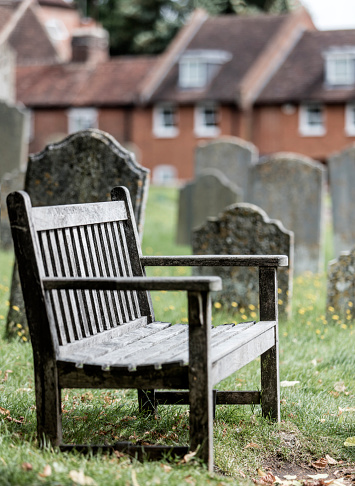Empty seat in a church graveyard, sadness metaphor