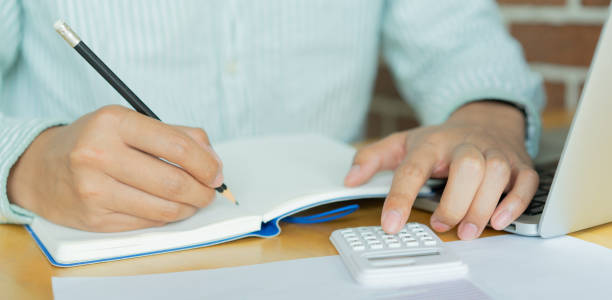 istock close up on man hand write on notebook and calculate on calculator about debt payment monthly at the table for money management concept 1398146050