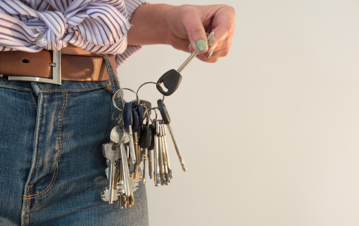 A large bunch of keys does not fit into a jeans pocket for a young woman