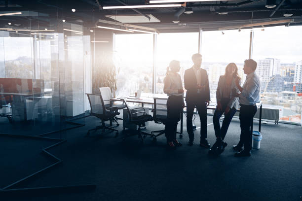 istock Business team standing against panoramic windows in modern office 1398149431