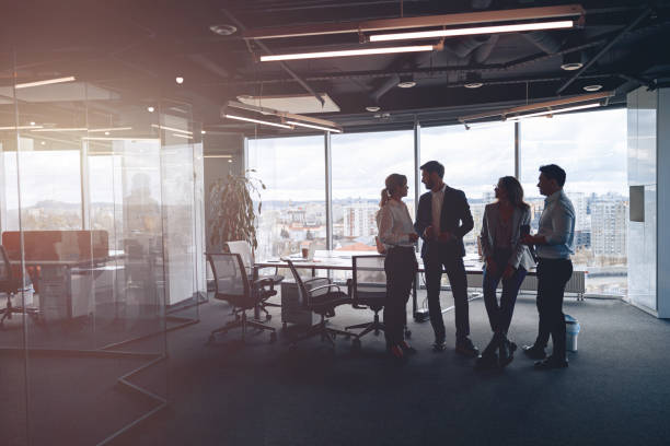 istock Business team standing against panoramic windows in modern office 1398149432