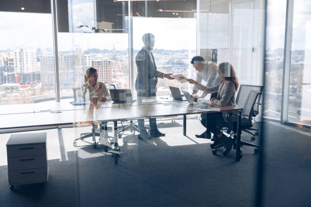 istock Creative business people working on new project in modern office with panoramic view 1398149434