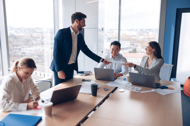 istock Creative business people working on new project in modern office with panoramic view 1398149458