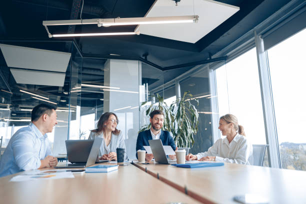 istock Creative business people working on project in modern office with panoramic view 1398149483