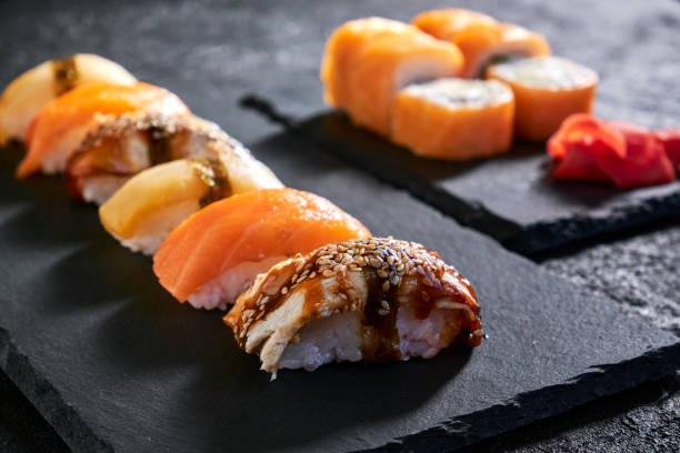istock Assorted sushi with salmon, eel and escolar on black stone plate on dark background 1398150660