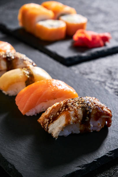 istock Assorted sushi with salmon, eel and escolar on black stone plate on dark background 1398150663
