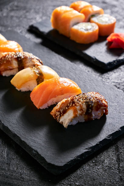 istock Assorted sushi with salmon, eel and escolar on black stone plate on dark background 1398150670