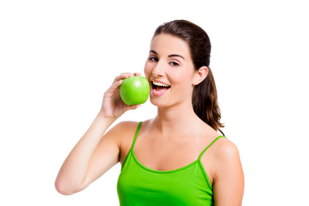 здоровая женщина ест apple - apple women green eating стоковые фото и изображения