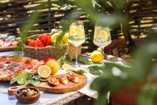 Limoncello Spritz drink aperitif at Italian food table with antipasti and pizza selection stock photo