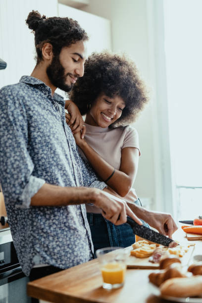istock Multi ethnic couple at home in kitchen, both people smiling and enjoying time together 1398154989