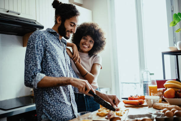 istock Multi ethnic couple at home in kitchen, both people smiling and enjoying time together 1398154990