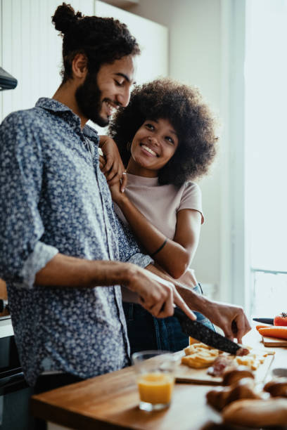 istock Multi ethnic couple at home in kitchen, both people smiling and enjoying time together 1398154994