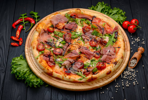 istock Delicious pizza with prosciutto and arugula. 1398155847
