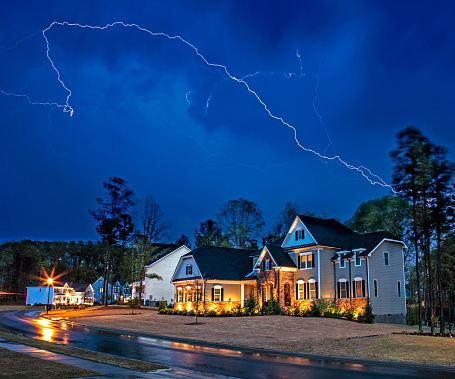 New Hill, North Carolina, USA: April 8th 2020; Powerful lightning storm front passes over residential houses