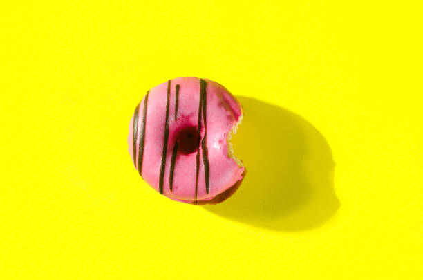 istock Pink donut on yellow background 1398171472