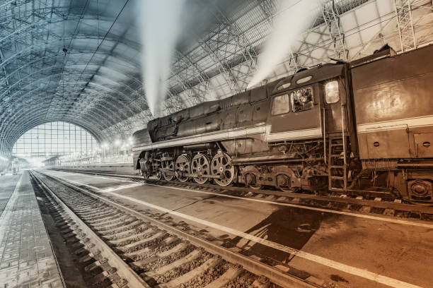Retro steam train stands by the railway station.