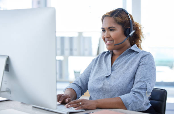 istock One happy young mixed race female call centre telemarketing agent talking on a headset while working on a computer in an office. Confident and friendly african american businesswoman consultant operating a helpdesk for customer service and sales support 1398177638