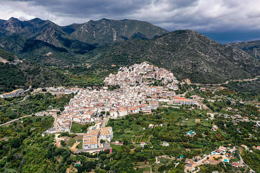 Aerial perspective of Ojen village, small white Andalusian town located in the mountains, in the heart of the Costa del Sol, not far from Marbella. In background beautiful mountains of Sierra Blanca
