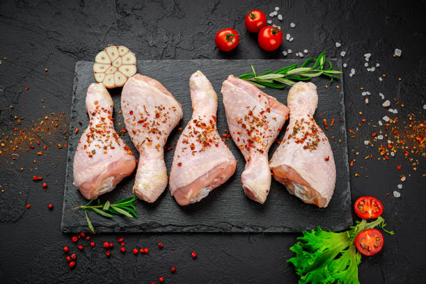 istock Raw chicken drumsticks with spices and vegetables. 1398180741