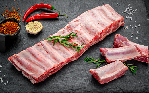raw pork ribs on a stone background. Fresh pork meat