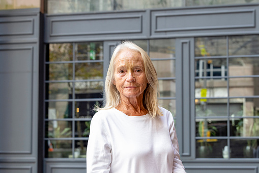 Portrait of modern senior woman in city, background with copy space, full frame horizontal composition