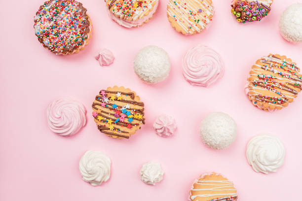 istock Handmade cookies and marshmallows lie on a pink background. 1398184472