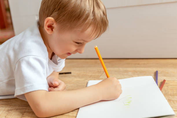 istock A little boy draws lying on the floor. 1398184590