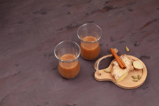istock Cutting chai or Indian ginger tea with milk and spices. Brown background, copy space.  Popular hot drink in India and Nepal 1398184653