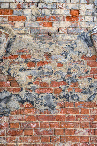 Grunge background, old red brick and plaster wall texture, abandoned exterior urban background.