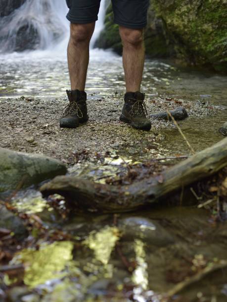 istock man in hiking boots standing by a waterfall 1398189813