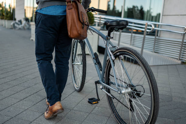 istock Side view of an unrecognizable modern man walking with his bicycle 1398194538