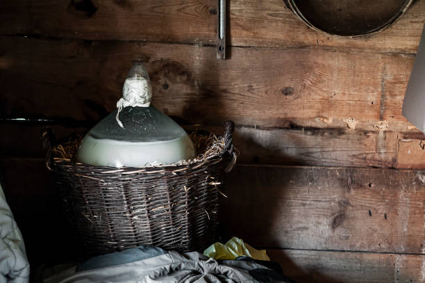 mondschein bereitet sich vor. großer glasballon mit brei im korb. - distillery still stock-fotos und bilder