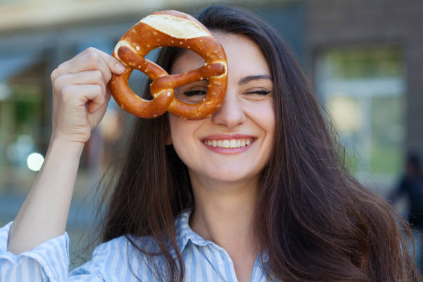 istock Young woman eating a pretzel 1398199370