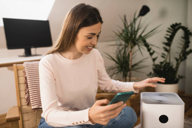 istock Woman turning her air purifier using a mobile app 1398204246