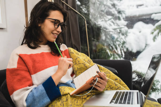 istock Young woman studying for the exam and warming under the blanket 1398204260