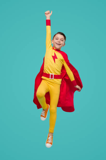 istock Happy superhero kid jumping with raised arm 1398204345
