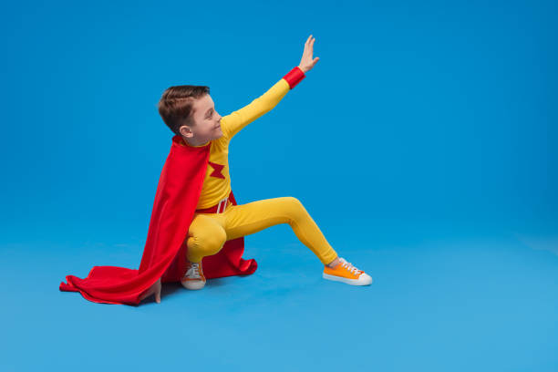 istock Superhero child waving hand in studio 1398204383