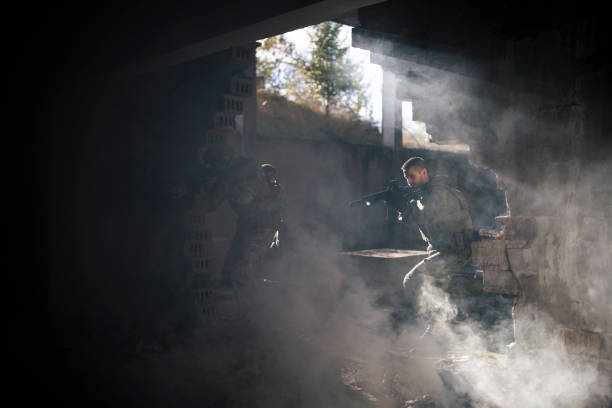 Soldiers with shotguns running through bombed building in war.