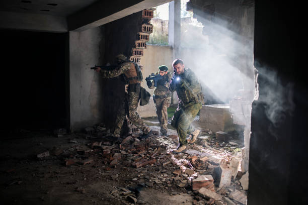 istock Soldiers with shotguns running through bombed building. 1398204803