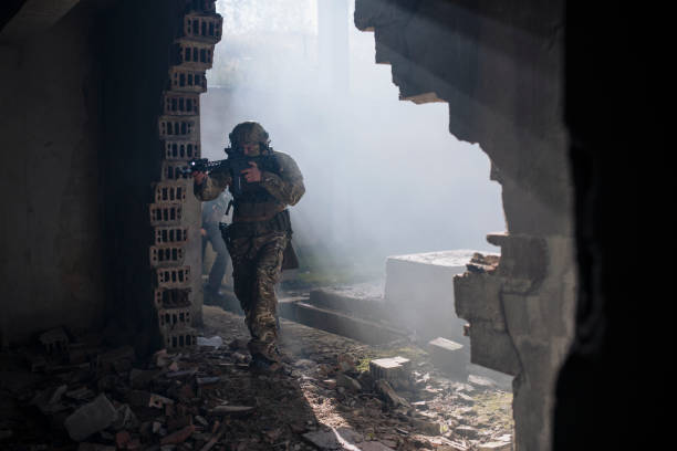 istock Soldiers with shotguns running through bombed building. 1398204925