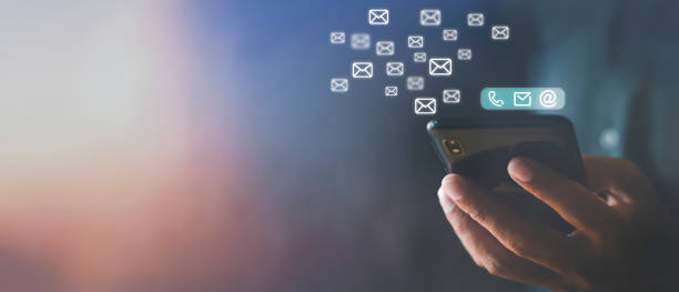 istock Hand holding using mobile phone with email icon on screen. Business communication technology concept. Hand man holds phone sent and receive email from internet. Copy space banner 1398210128