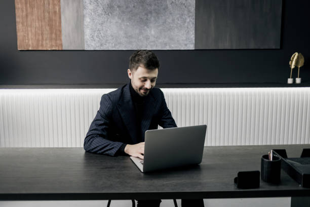 istock Happy young businessman using laptop at home. 1398211331