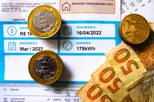 19 de mayo de 2022, brasil. una factura de electricidad (electricidad), que indica el consumo mensual de 175 kilovatios-hora (kwh), con billetes y monedas del real brasileño. - energy bill fotografías e imágenes de stock