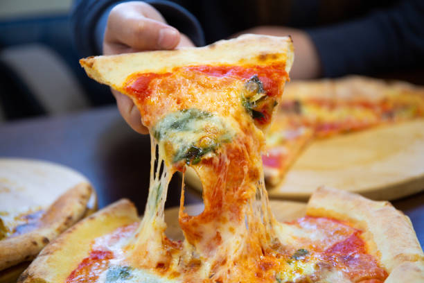 istock Picking up a slice of pizza with melted cheese stretching 1398212862
