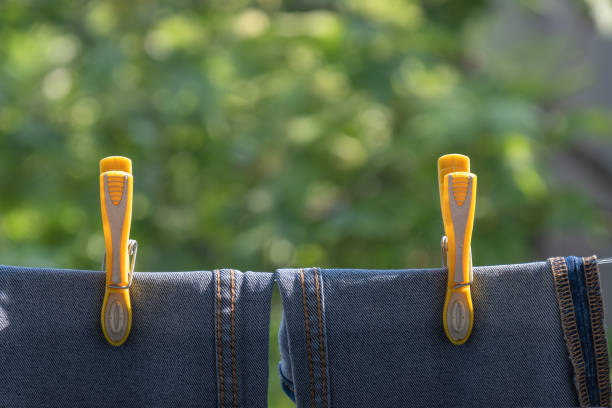 yellow color pegs hanging on clothesline, blue rope,