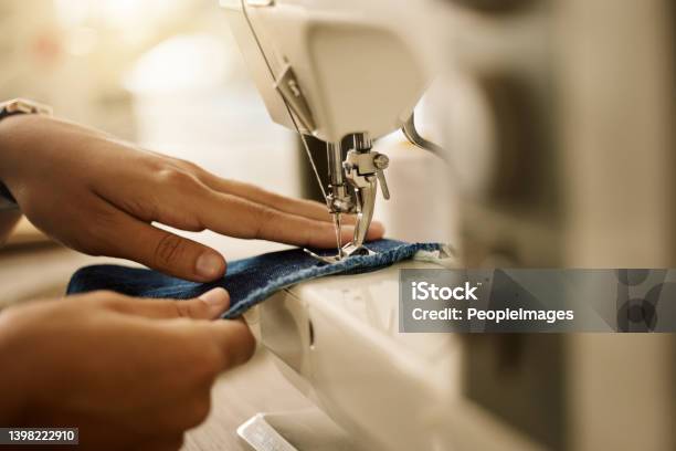 Zoom Into Hands Of A Seamstress Sewing A Piece Of Fabric Fashion Designer Stitching A Piece Of Fabriccloseup Of Designer Tailoring Denim Textile In A Sewing Machinetailor Using A Sewing Machine Stock Photo - Download Image Now