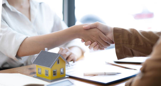 istock Real estate broker agent and customer shaking hands after signing contract documents for realty purchase, Bank employees congratulate, Concept mortgage loan approval. 1398223012