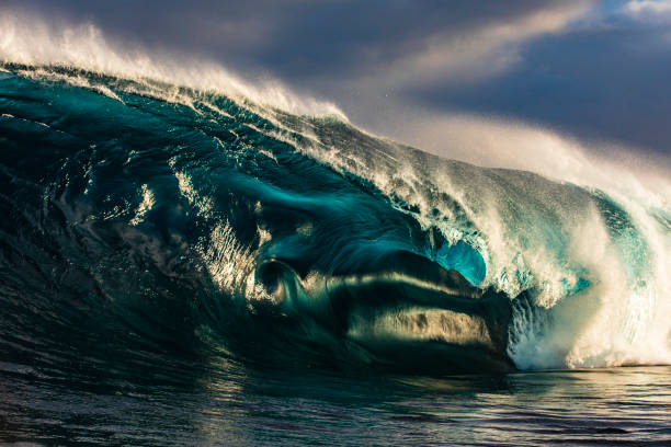 istock Large unique looking blue open ocean wave barrelling in warm morning light 1398225327
