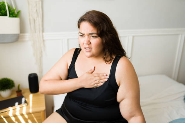 Woman with obesity suffering chest pain stock photo