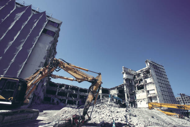 A long-reach excavator pulling apart an old office block.